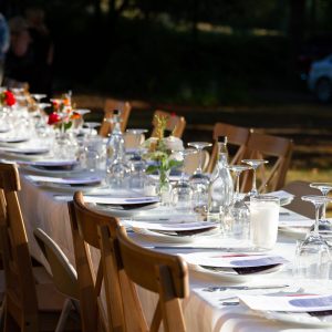 Table set outdoors farm style with glasses and wooden chairs