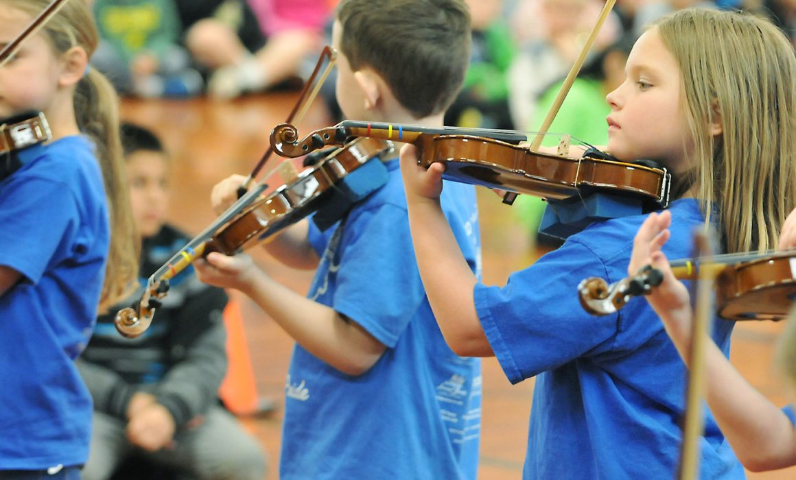Student musicians playing violins