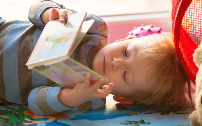 Toddler laying down reading