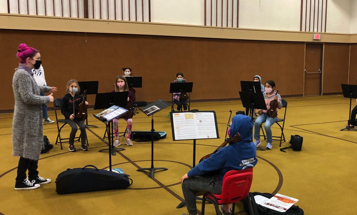 Music teacher with children around her